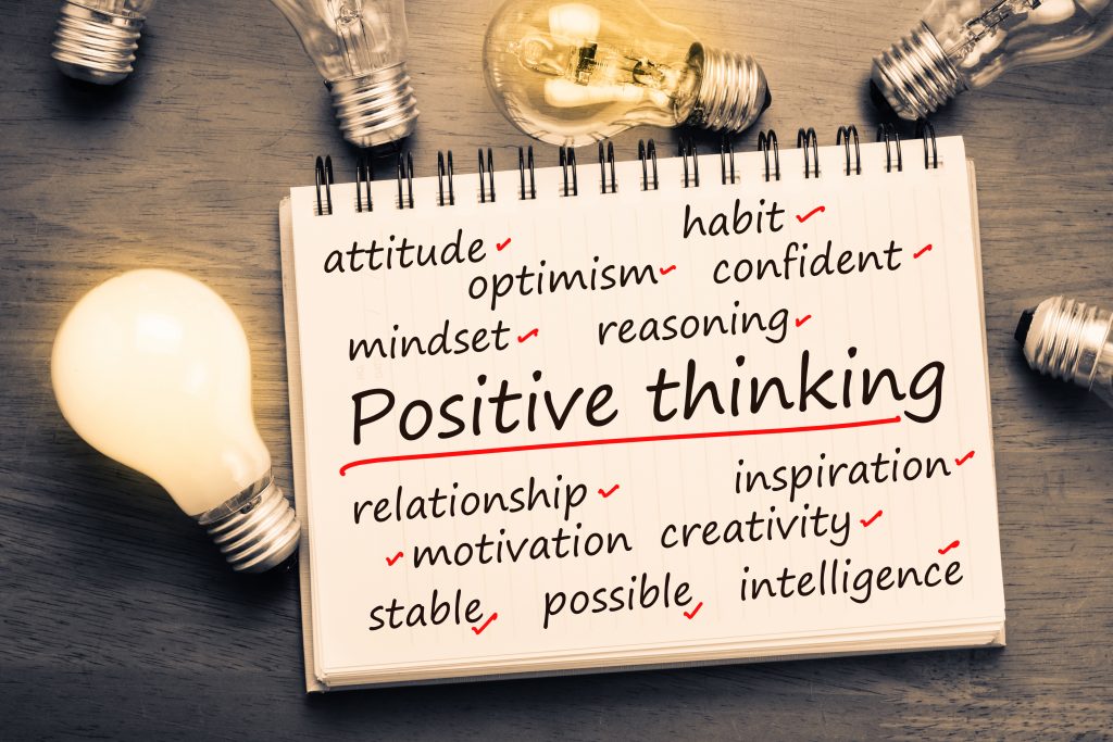 Positive Thinking factor concept on notebook with light bulbs